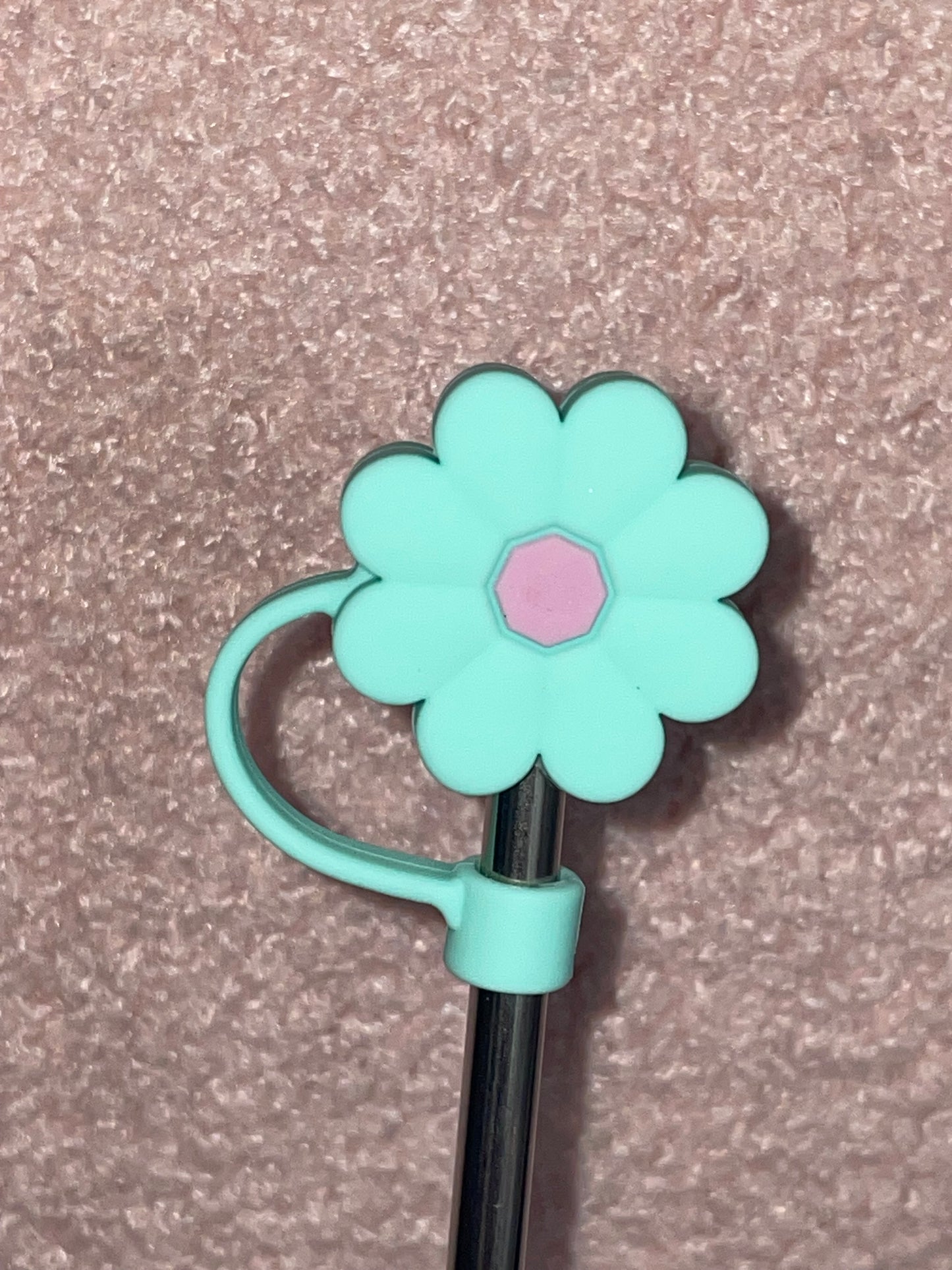 Flower-shaped clip with a pink center on a textured surface