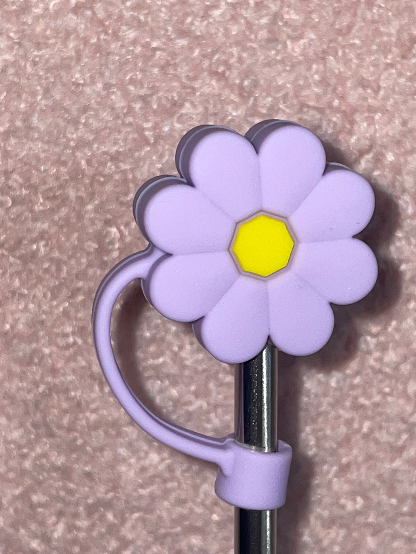 Purple flower-shaped holder with a yellow center on a textured surface