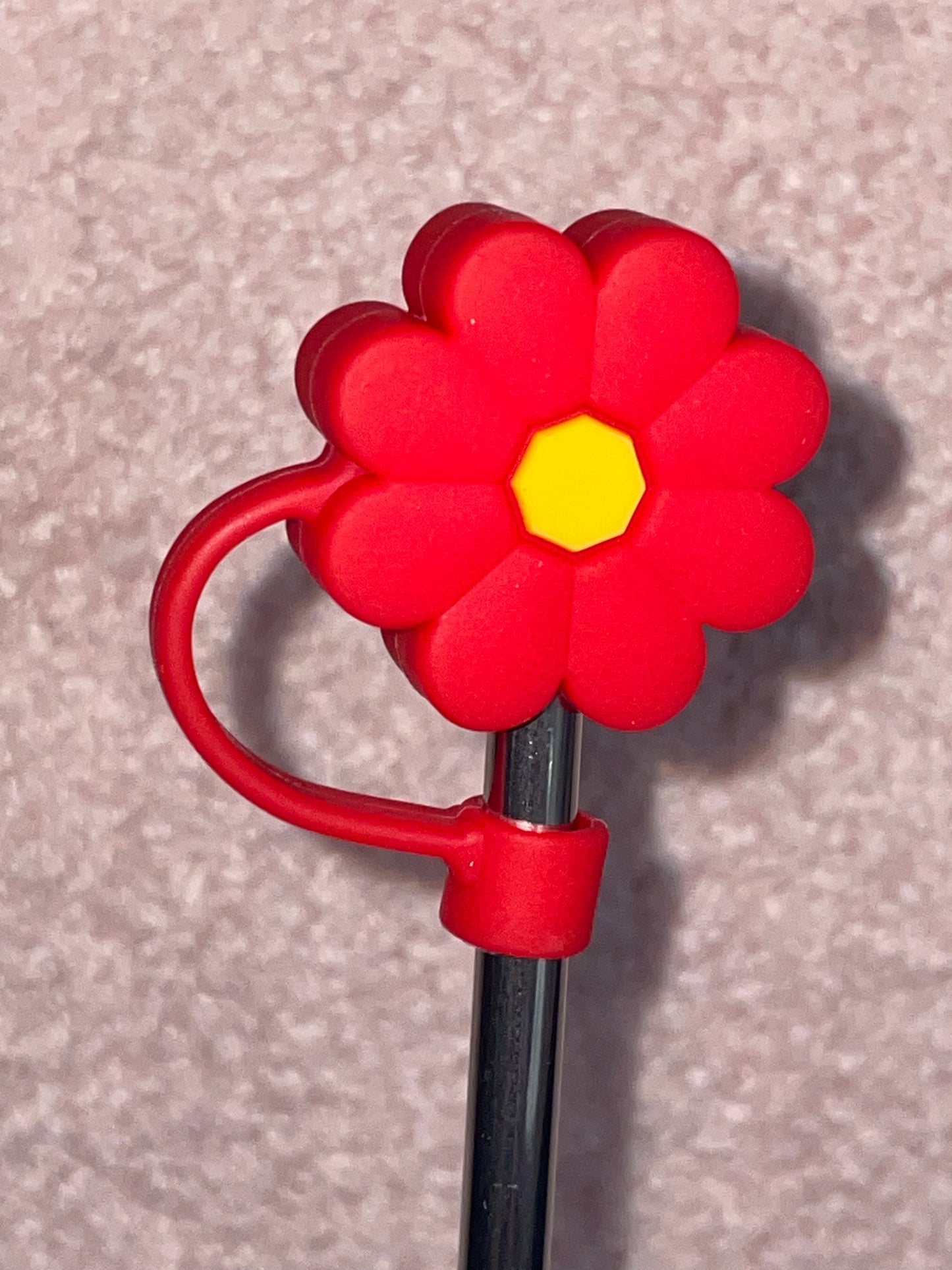 Red flower-shaped clip on a gray background