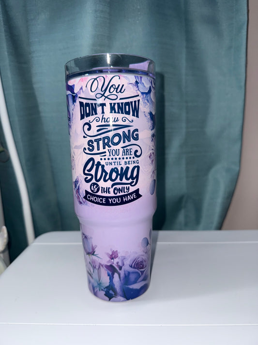 Tumbler with motivational quote on a blue surface