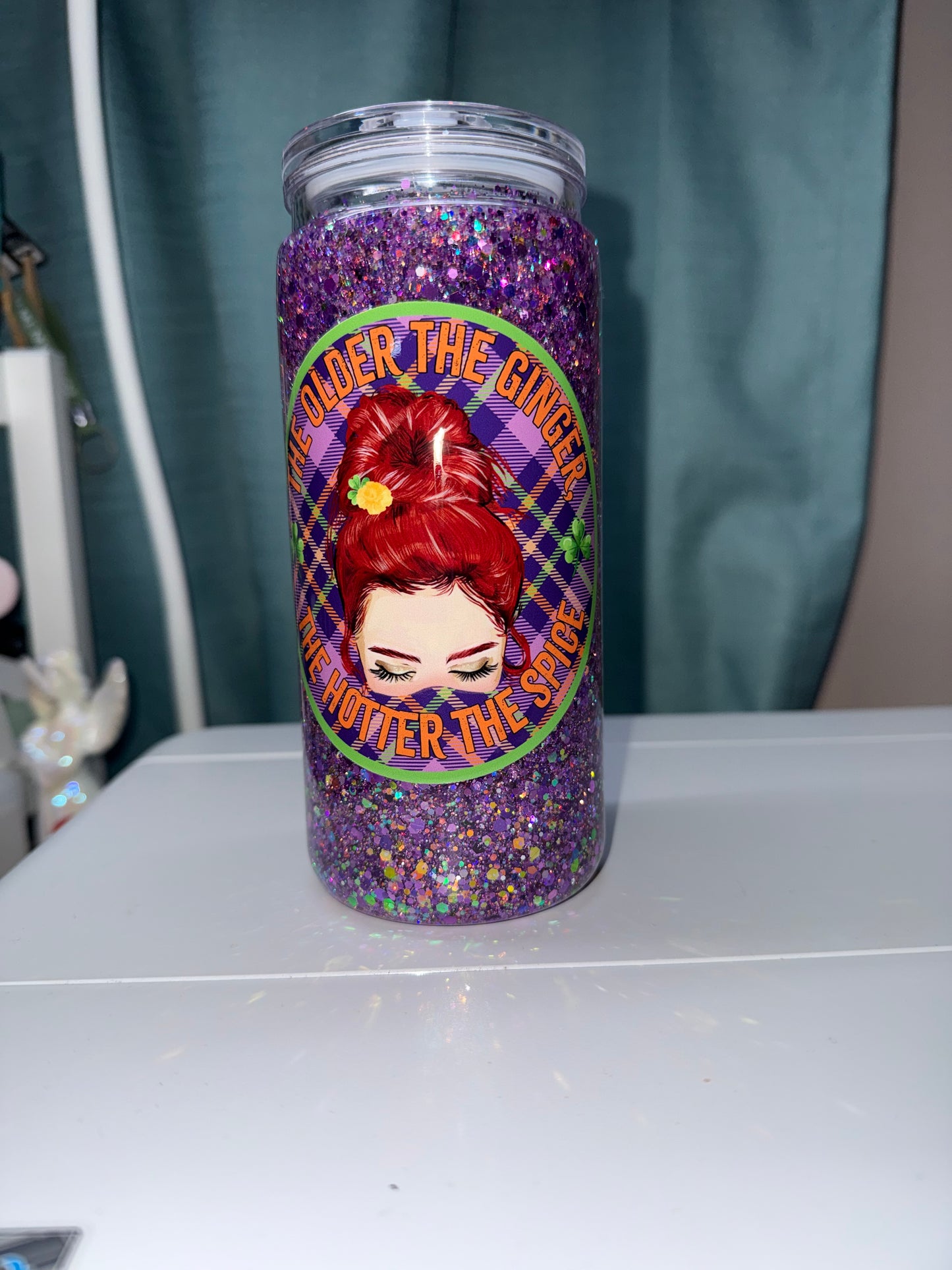 Tumbler with a colorful design featuring a face and text on a white background