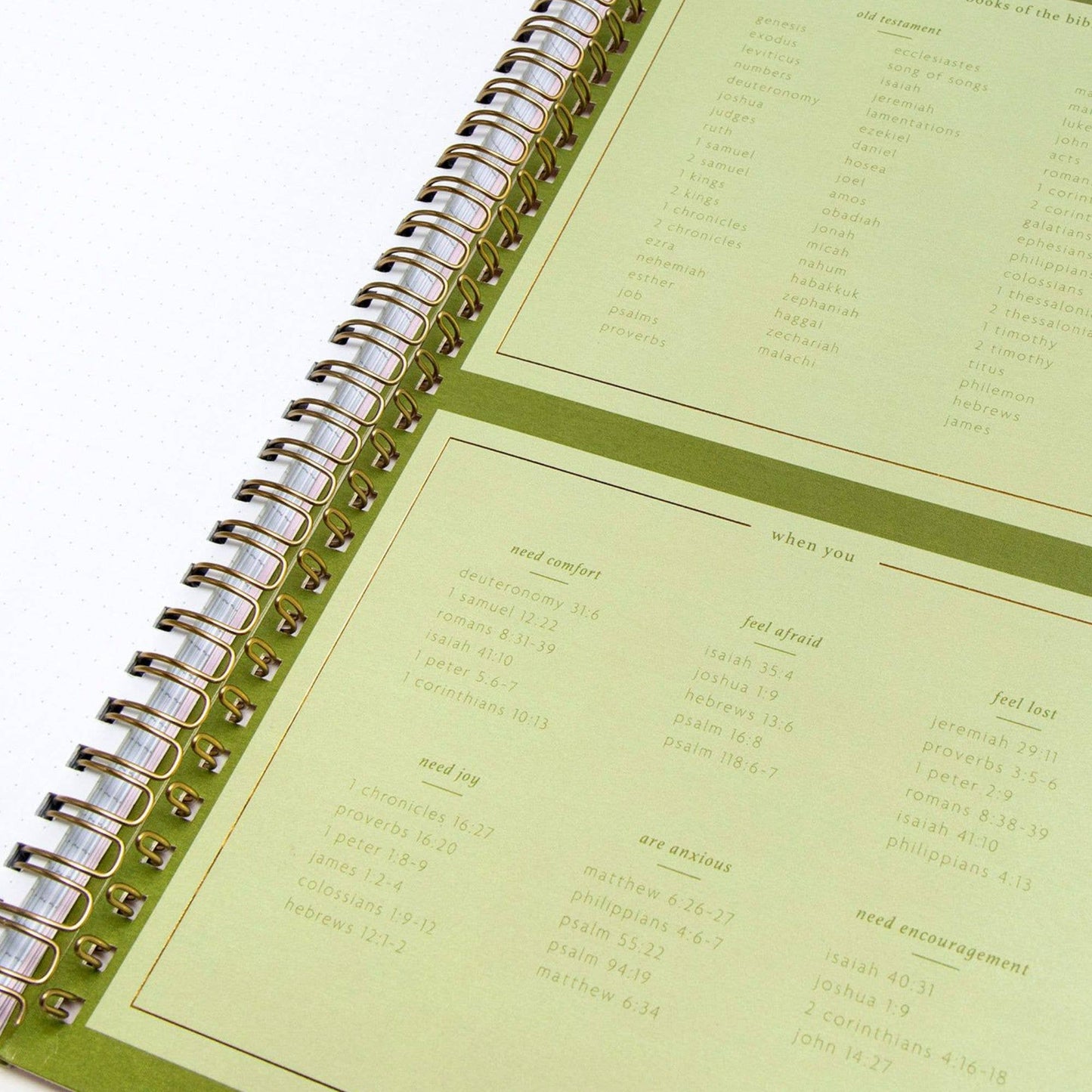Green spiral-bound notebook with text on a white background