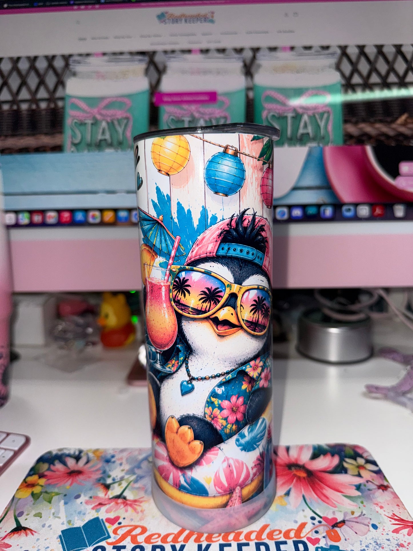 20 oz Too Cool To Care Tumbler - front view showing penguin in pink baseball cap and yellow sunglasses sipping tropical drink with lanterns and tropical leaves
