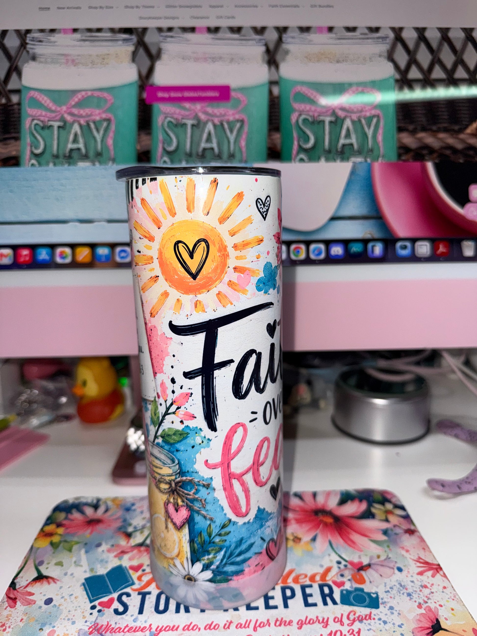 20 oz Faith Over Fear Tumbler - side view showing heart sun with Faith over fear in brush script and watercolor blue wash with mason jar wildflowers