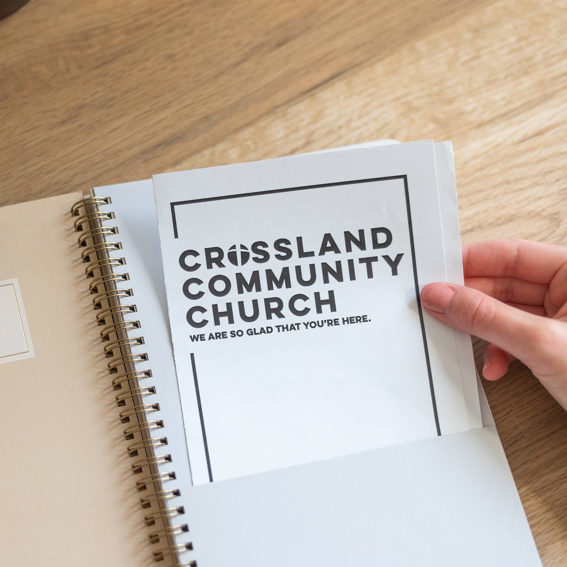 Open book with 'Crossland Community Church' message on a wooden surface