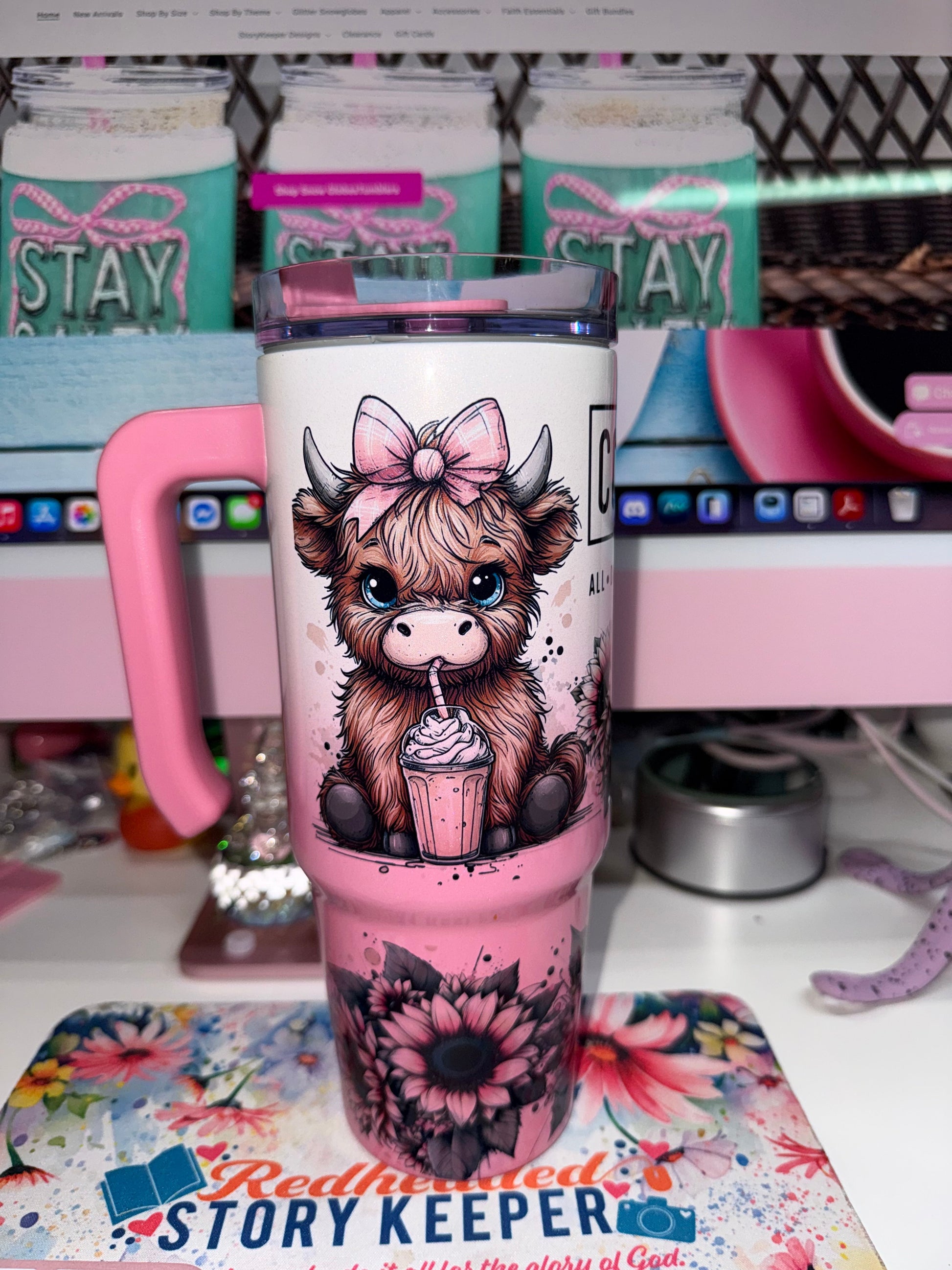30 oz Coffee Mode Grippy Tumbler Limited Edition - side view showing adorable highland cow with pink bow and blue eyes sipping a frappé surrounded by pink sunflowers