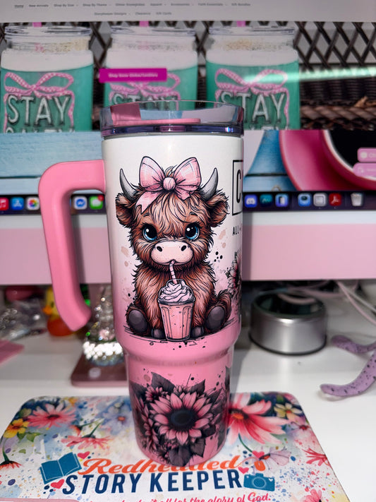 30 oz Coffee Mode Grippy Tumbler Limited Edition - side view showing adorable highland cow with pink bow and blue eyes sipping a frappé surrounded by pink sunflowers