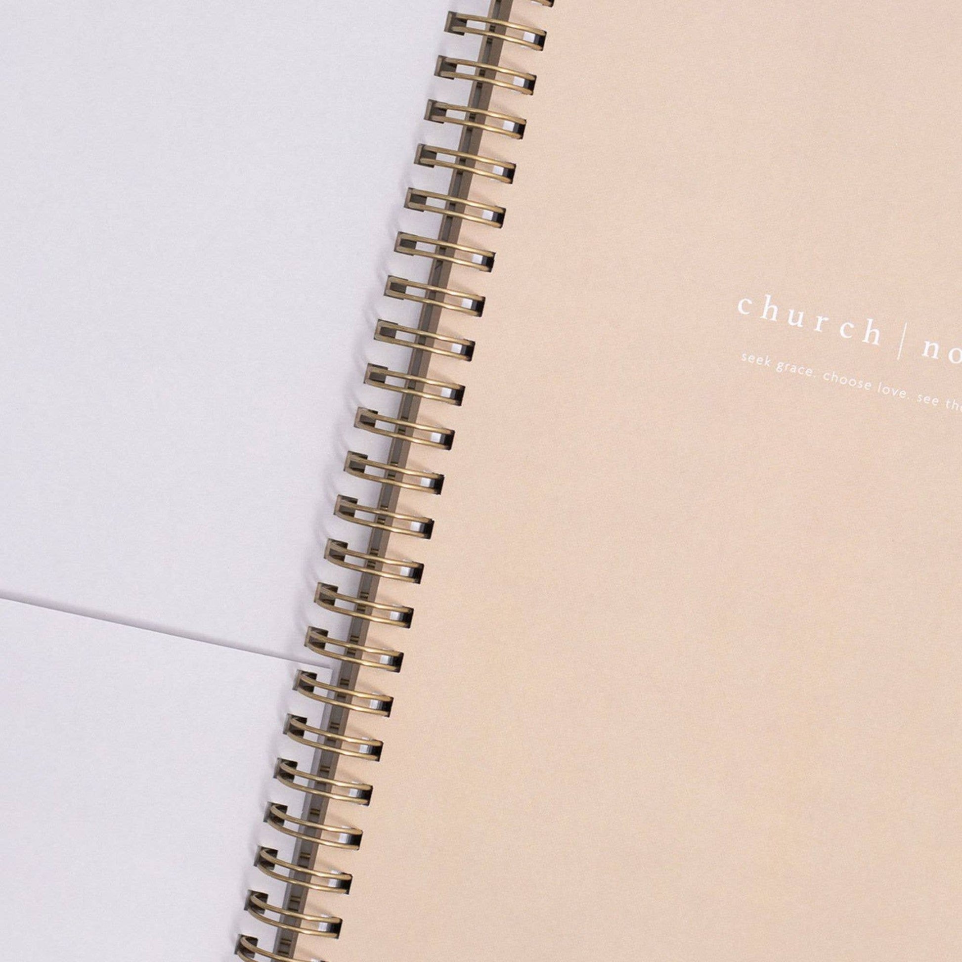 Close-up of a spiral-bound notebook with 'church & nord' branding on a light background