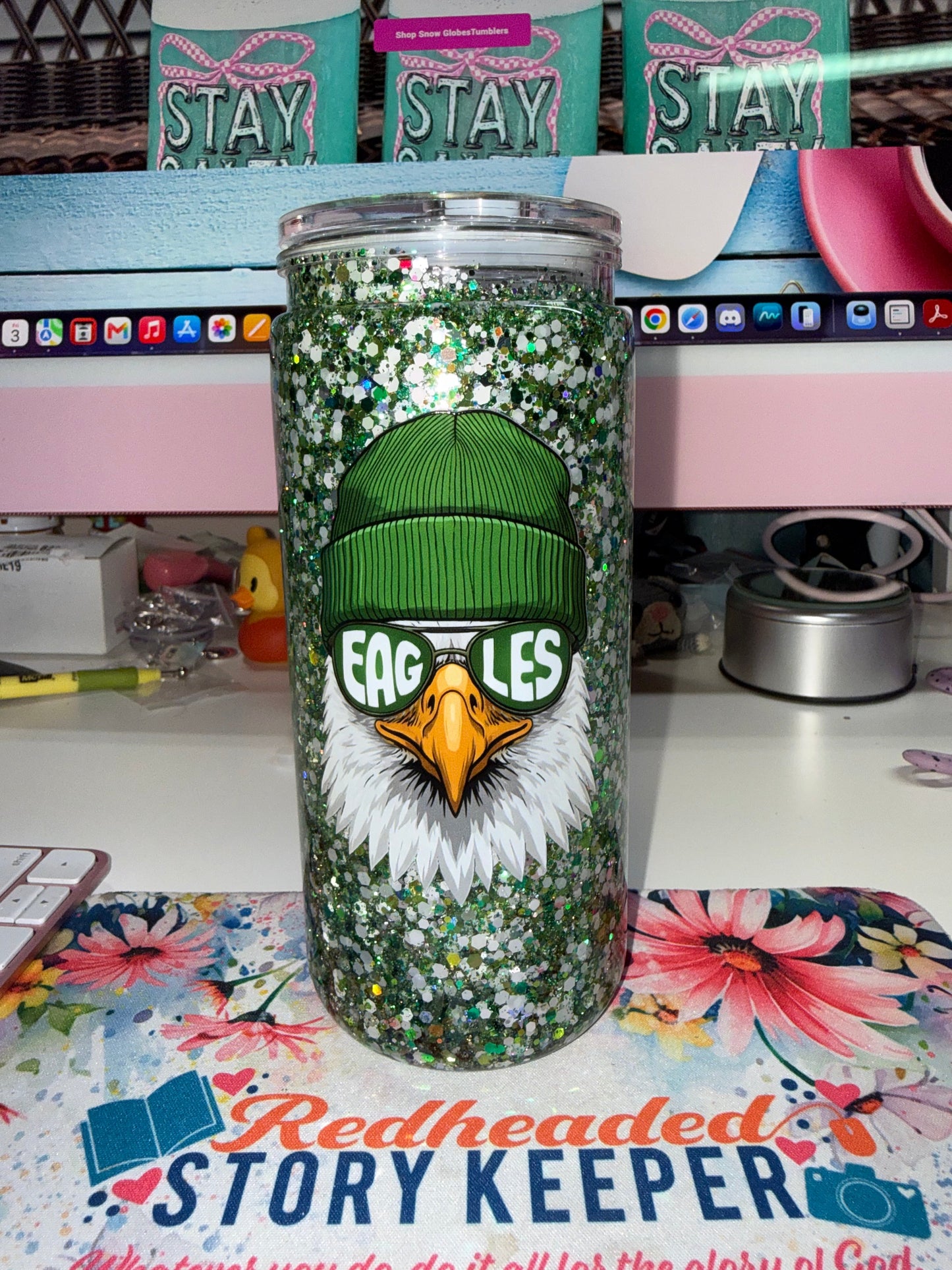 20 oz Eagles Glitter Tumbler - front view showing Philadelphia Eagles bald eagle mascot in green beanie with EAGLES sunglasses on chunky green and holographic glitter background