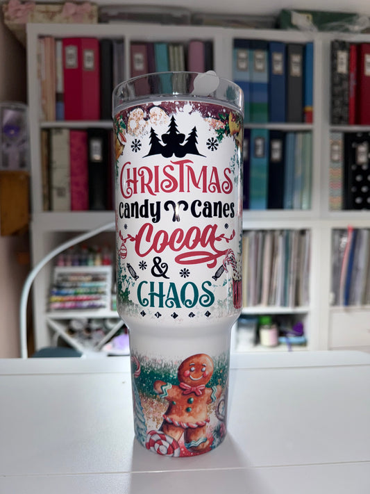Tumbler with Christmas-themed design featuring candy canes, cocoa, and chaos text.