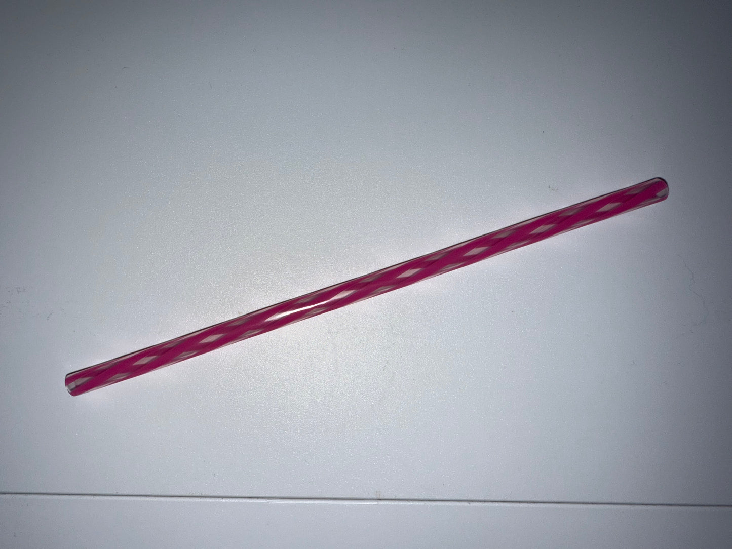 Pink straw on a white background
