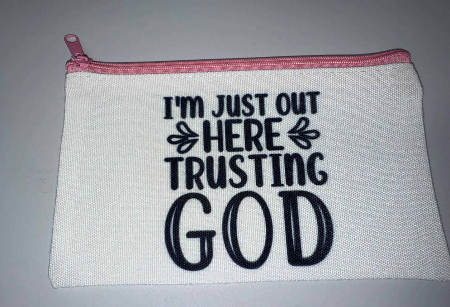 White pouch with pink zipper and black text on a gray background