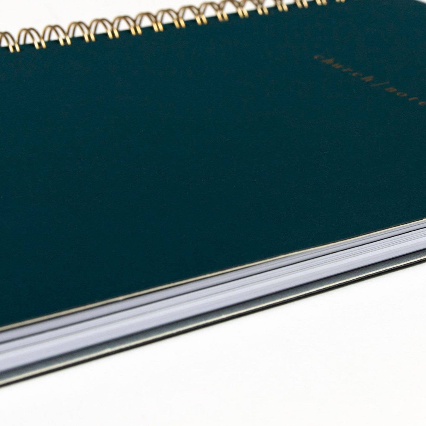 Green notebook with gold wire binding on a white background