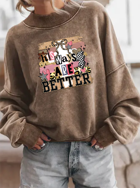 Brown sweatshirt with graphic design and text worn by a person indoors.