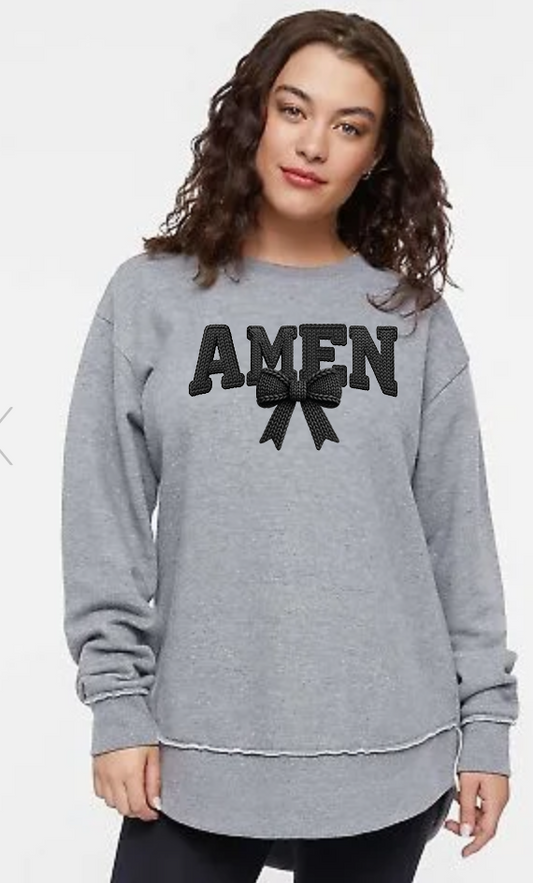 Woman wearing a gray sweatshirt with 'AMEN' and bow design on a white background